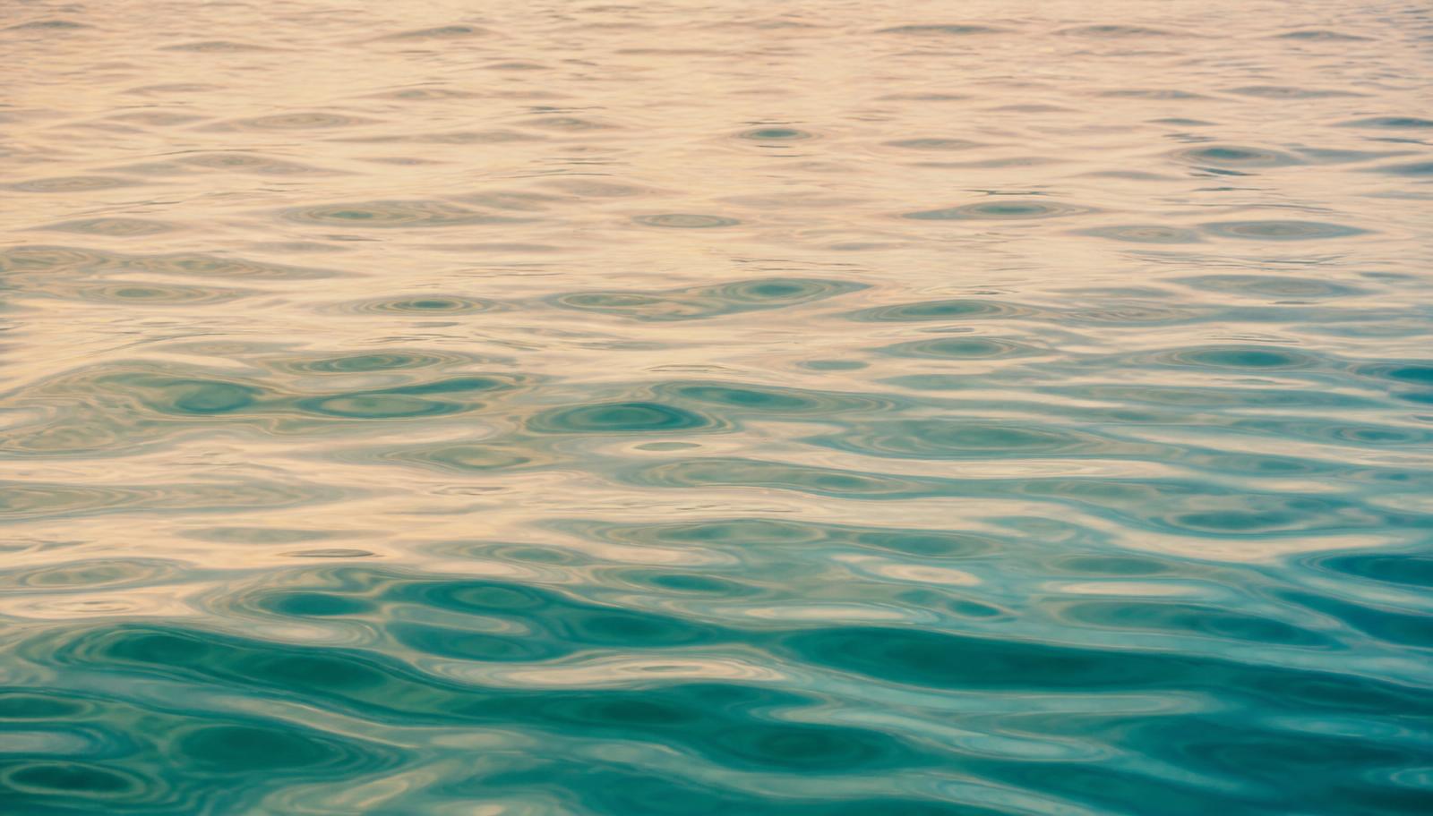 Calm ocean surface with soft ripples in warm afternoon light